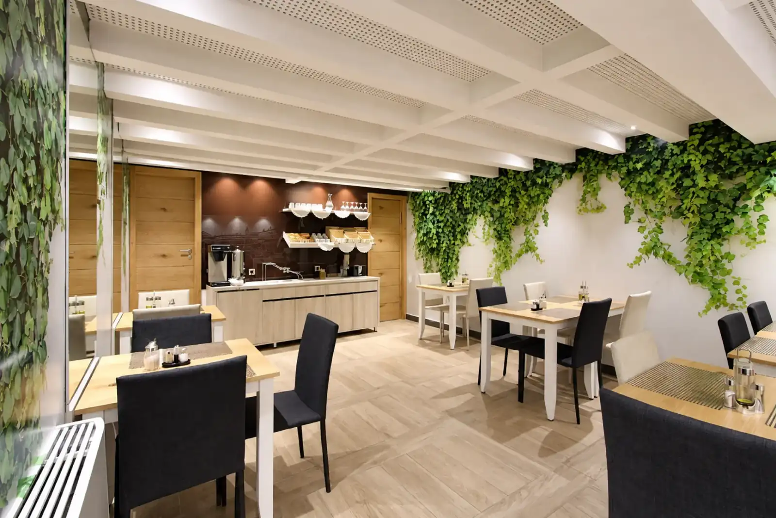 Dining tables and breakfast serving area in Hotel Cosmopolit restaurant