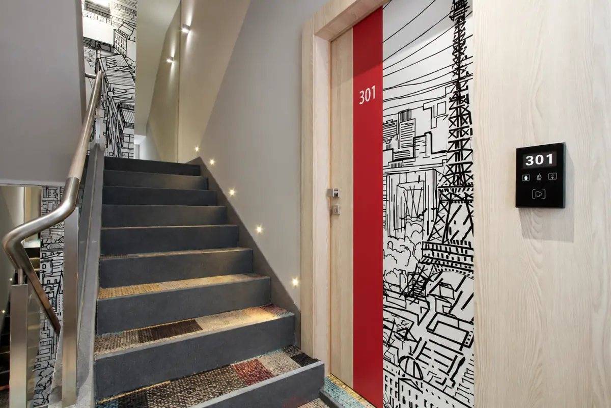 Hotel Cosmopolit staircase and guest room 301 entrance with illustrated door