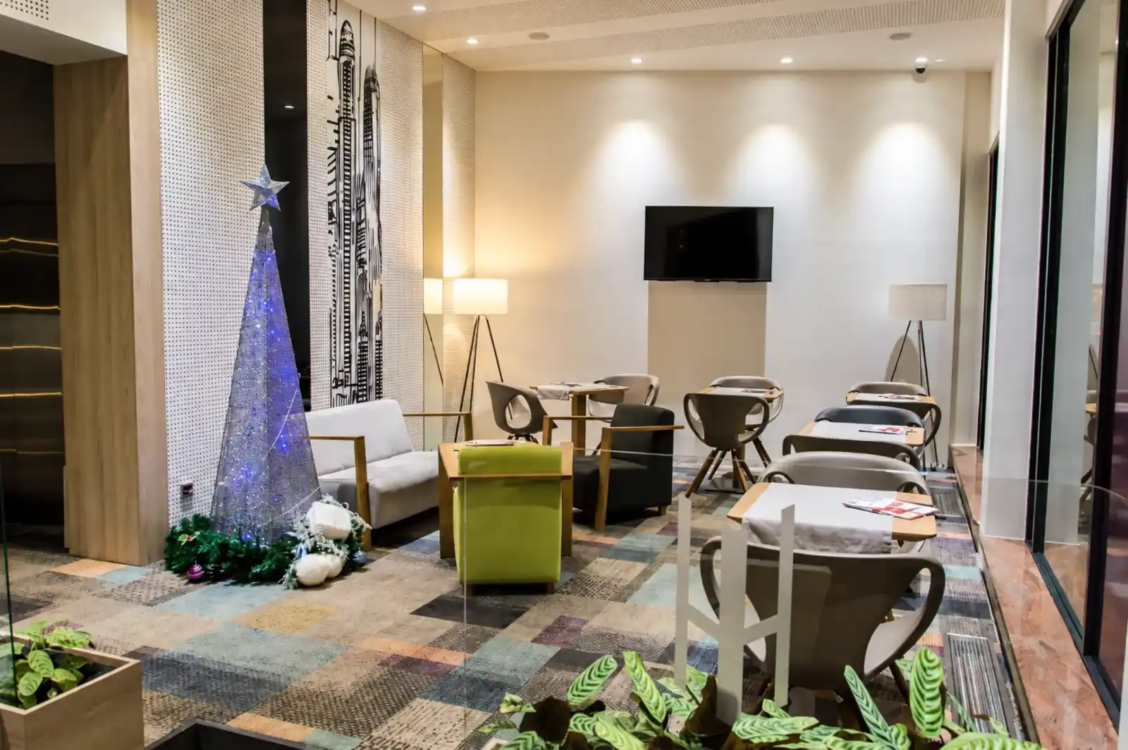 Hotel Cosmopolit shared lounge with armchairs, tables and television