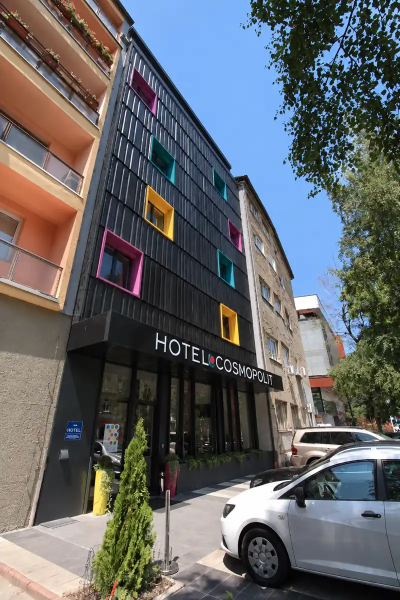 Hotel Cosmopolit facade and entrance with colorful window frames viewed from the street